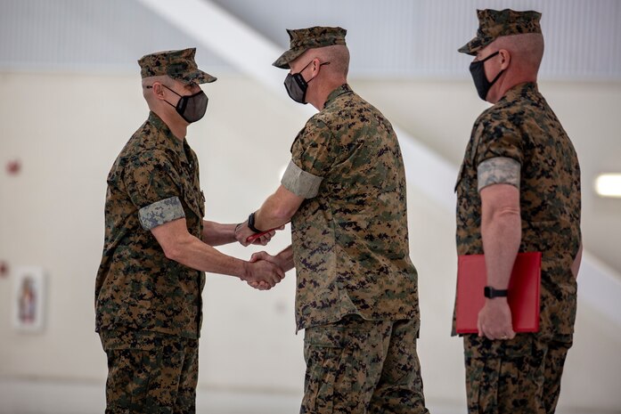U.S. Marine Corps Sgt. Maj. Carlos A. Orjuela, left, the outgoing sergeant major, Marine Corps Air Station New River is awarded during the New River sergeant major relief and appointment ceremony at the Center for Naval Aviation Technical Training on MCAS New River, North Carolina, April 16, 2021. The relief and appointment ceremony symbolized the passing of responsibilities and duties from Orjuela to the incoming sergeant major, Sgt. Maj. Douglas W. Gerhardt. (U.S. Marine Corps Lance Cpl. Isaiah Gomez)