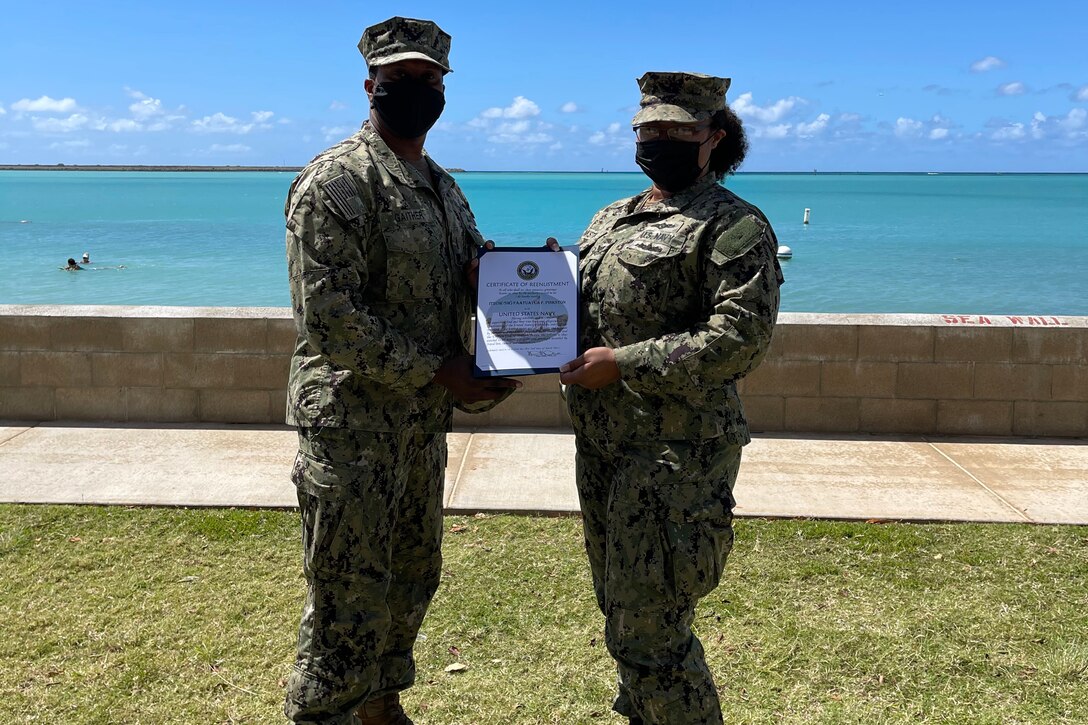 A woman and man, both in uniform, hold a certificate.