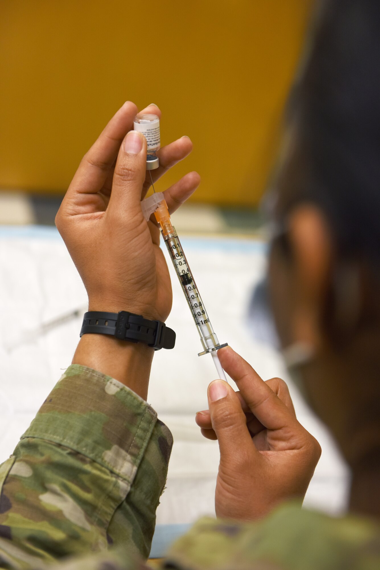 U.S. Air Force Tech. Sgt. Melan Davenport, 62nd Medical Squadron independent duty medical technician, fills a vile with a dose of the Pfizer vaccine at the 62nd Medical Squadron Airman’s Clinic, Joint Base Lewis-McChord, Washington, April 14, 2021. Once reconstituted, a Pfizer vaccine dose must be administered within six hours or disposed of. (U.S. Air Force photo by Senior Airman Mikayla Heineck)