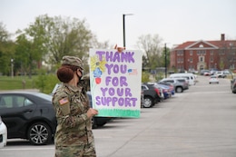 soldier holds sign supporting military children at Kingsolver Elementary School