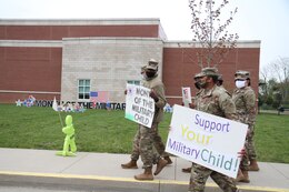 soldiers hold signs supporting military children