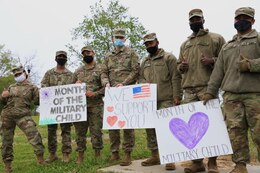 soldiers hold signs supporting the month of the military child