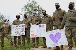 soldiers hold signs supporting the month of the military child