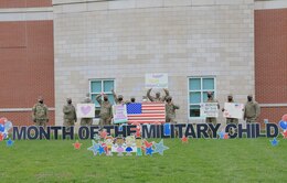 soldiers hold signs supporting the Month of the Military Child