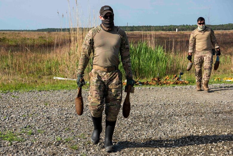 Staff Sgt. George Altosino, left, and Senior Airman Cory Mclellan, 4th Civil Engineer Squadron explosive ordinance disposal technicians, recover left behind bomb dummy units (BDU) at Dare County Bomb Range, North Carolina, April 19, 2021.