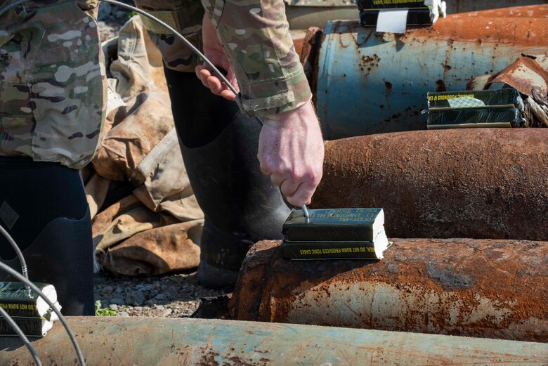 Staff Sgt. George Altosino 4th Civil Engineer Squadron explosive ordinance disposal Technician, places an ignition cap inside of C-4 explosives in preparation for a controlled explosion at Dare County Bomb Range, North Carolina, April 19, 2021