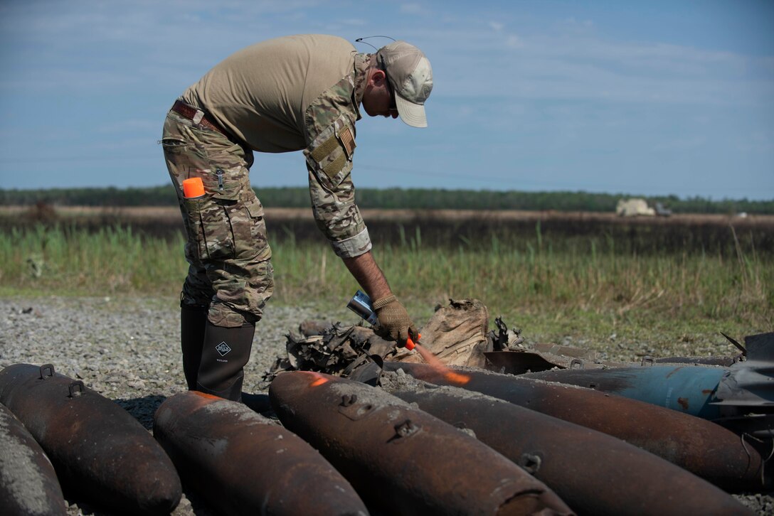 Staff Sgt. Ryan Carel, 4th Civil Engineer Squadron explosive ordinance disposal technician marks a bomb dummy unit (BDU) at Dare County Bomb Range, North Carolina, April 19, 2021.