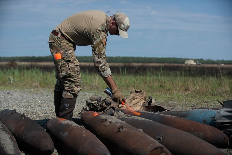 Staff Sgt. Ryan Carel, 4th Civil Engineer Squadron explosive ordinance disposal technician marks a bomb dummy unit (BDU) at Dare County Bomb Range, North Carolina, April 19, 2021.