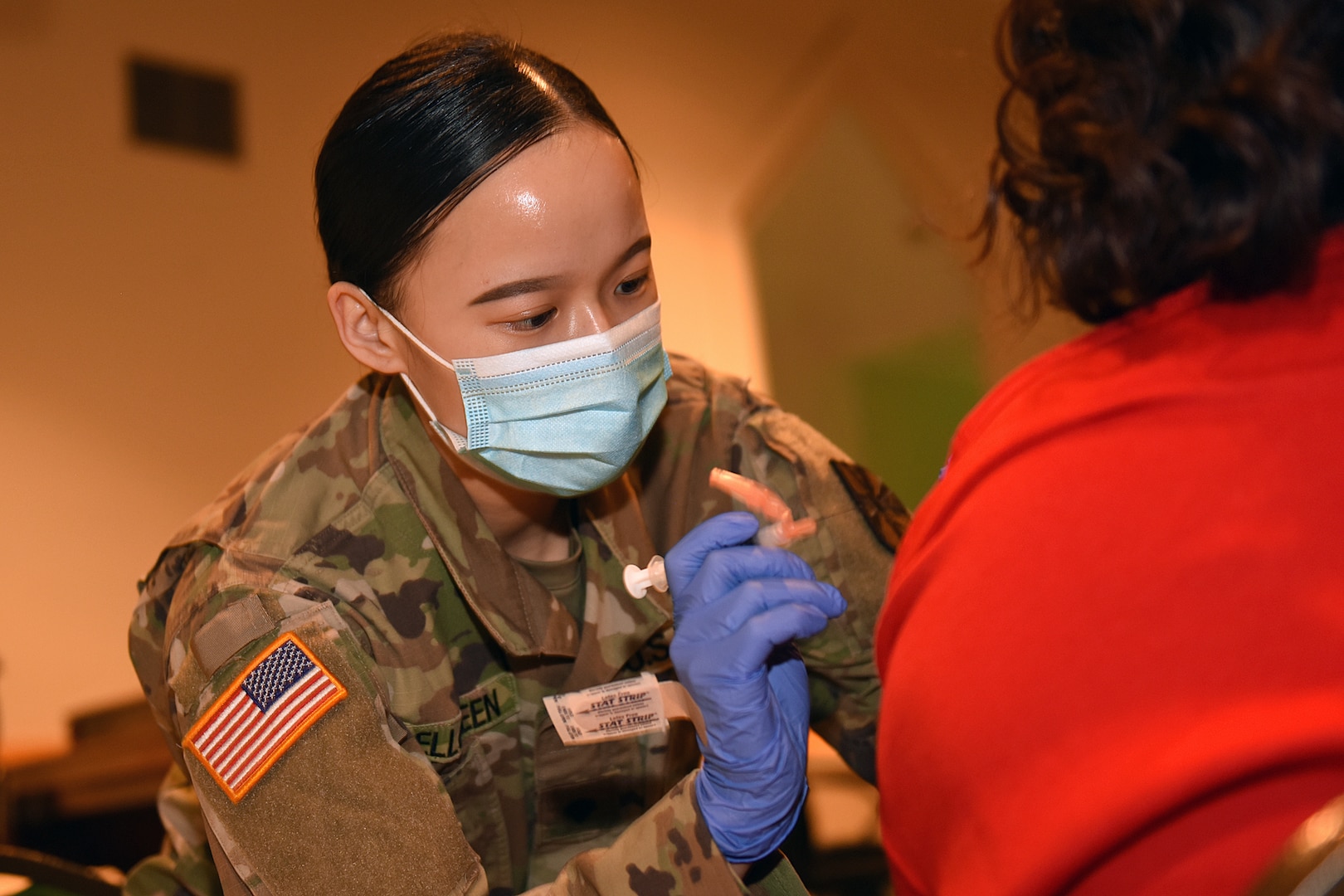 U.S. Army Spc. Melissa Bellgreen, a combat medic with the Michigan Army National Guard, assists the Genesee County Health Department at a vaccination clinic at a church in Flint, Michigan, April 9, 2021. Bellgreen came to the United States from China when she was a 1-year-old and became a U.S. citizen at the age of 8.