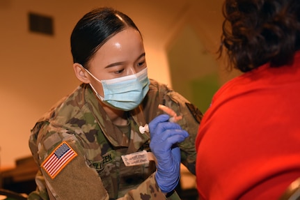 U.S. Army Spc. Melissa Bellgreen, a combat medic with the Michigan Army National Guard, assists the Genesee County Health Department at a vaccination clinic at a church in Flint, Michigan, April 9, 2021. Bellgreen came to the United States from China when she was a 1-year-old and became a U.S. citizen at the age of 8.