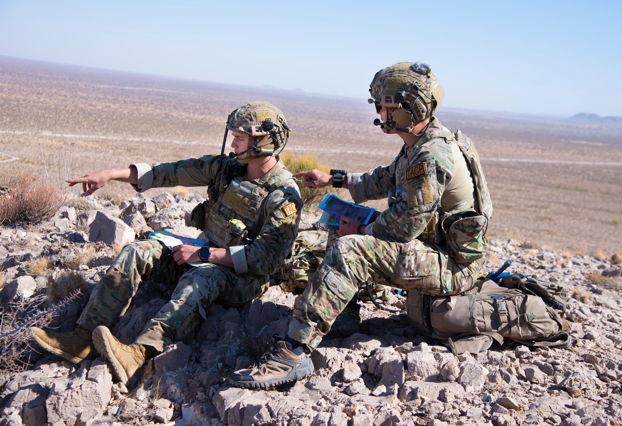 Two U.S. Air Force Tactical Air Control Party specialists look out at a simulated village during the 2021 Wraith Challenge, April 22, 2021, on Fort Bliss, Texas. Before communicating with air units, TACP specialists must work with the ground commander to analyze an area and work out a plan of attack. (U.S. Air Force photo by Airman 1st Class Jessica Sanchez)