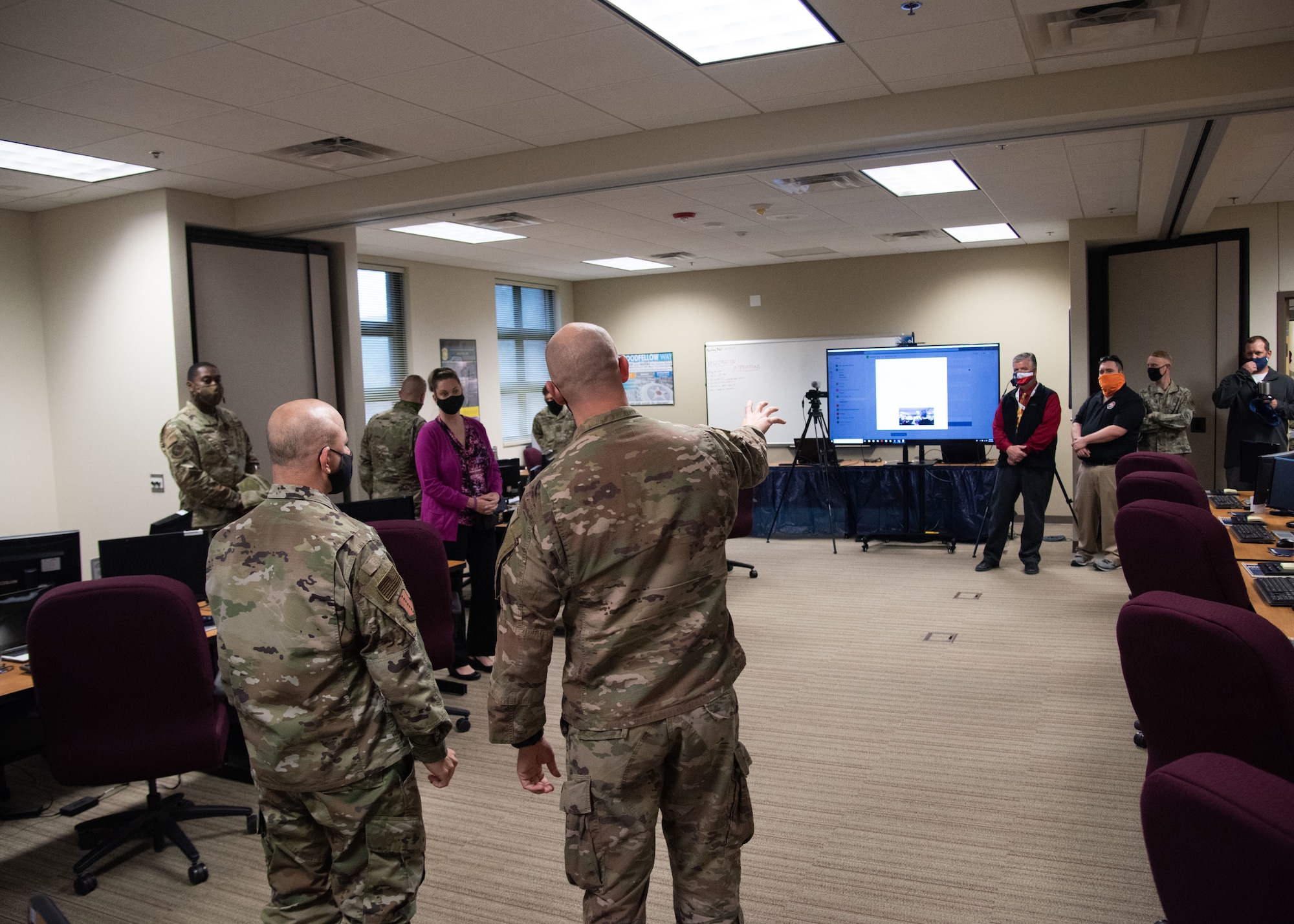 U.S. Air Force Capt. Matthew Riddle 315th Training Squadron officer in charge of the intelligence officer course team, center, showcases the Virtual Telecommunications system to Col. Andres Nazario, 17th Training Wing commander, left, in the Consolidated Learning Center on Goodfellow Air Force Base, Texas, April 15, 2021. This VTC was used to host intelligence leaders during a discussion about the intelligence career field. (U.S. Air Force photo by Staff Sgt. Tyrell Hall)