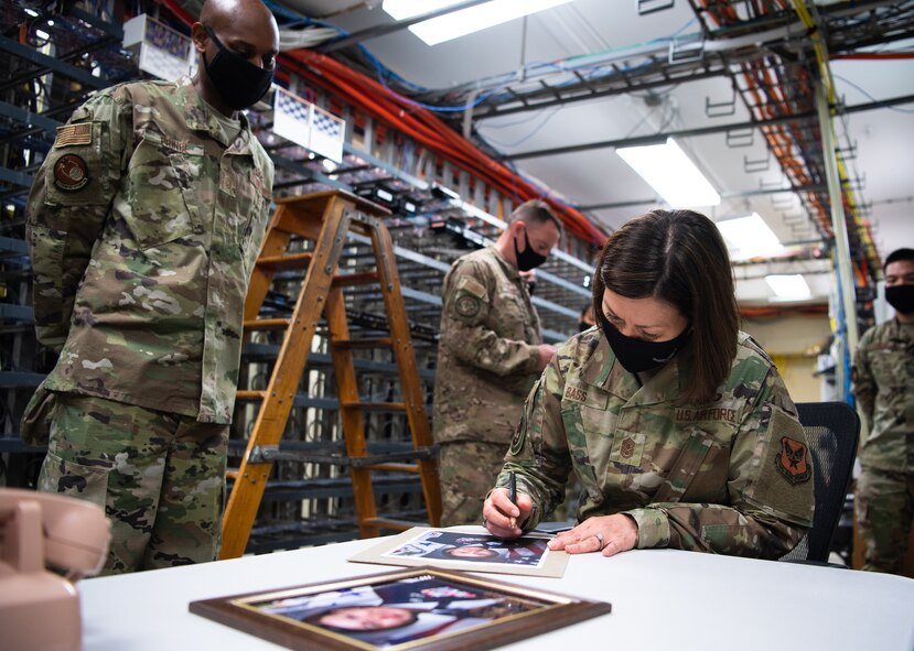 Chief Master Sgt. of the Air Force JoAnne S. Bass signs photos for the 2nd Communications Squadron during her visit to Barksdale Air Force Base, Louisiana, April 22, 2021. Bass spent her time at Barksdale visiting Airmen and getting familiar with their role in providing the nation with global bomber capabilities. (U.S. Air Force photo by Airman 1st Class Jacob B. Wrightsman)