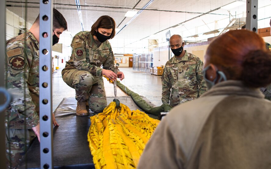 Chief Master Sgt. of the Air Force JoAnne S. Bass learns how to pack a B-52H Stratofortress parachute during her visit to Barksdale Air Force Base, Louisiana, April 22, 2021. Bass spent time with Airmen from across the installation, learning about their role in the mission of providing the nation with global strike capabilities. (U.S. Air Force photo by Airman 1st Class Jacob B. Wrightsman)