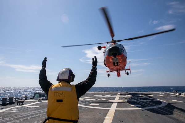 Boatswain’s Mate 3rd Class Dillon Coakley guides an MH-65 Dolphin helicopter to land on the Arleigh Burke-class guided-missile destroyer USS Roosevelt (DDG 80) on April 26, 2021.