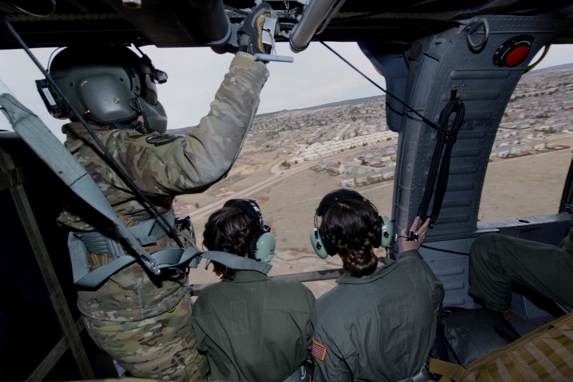 Cadets and a special missions’ aviator (left) fly aboard an HH 60-G helicopter above Colorado Springs