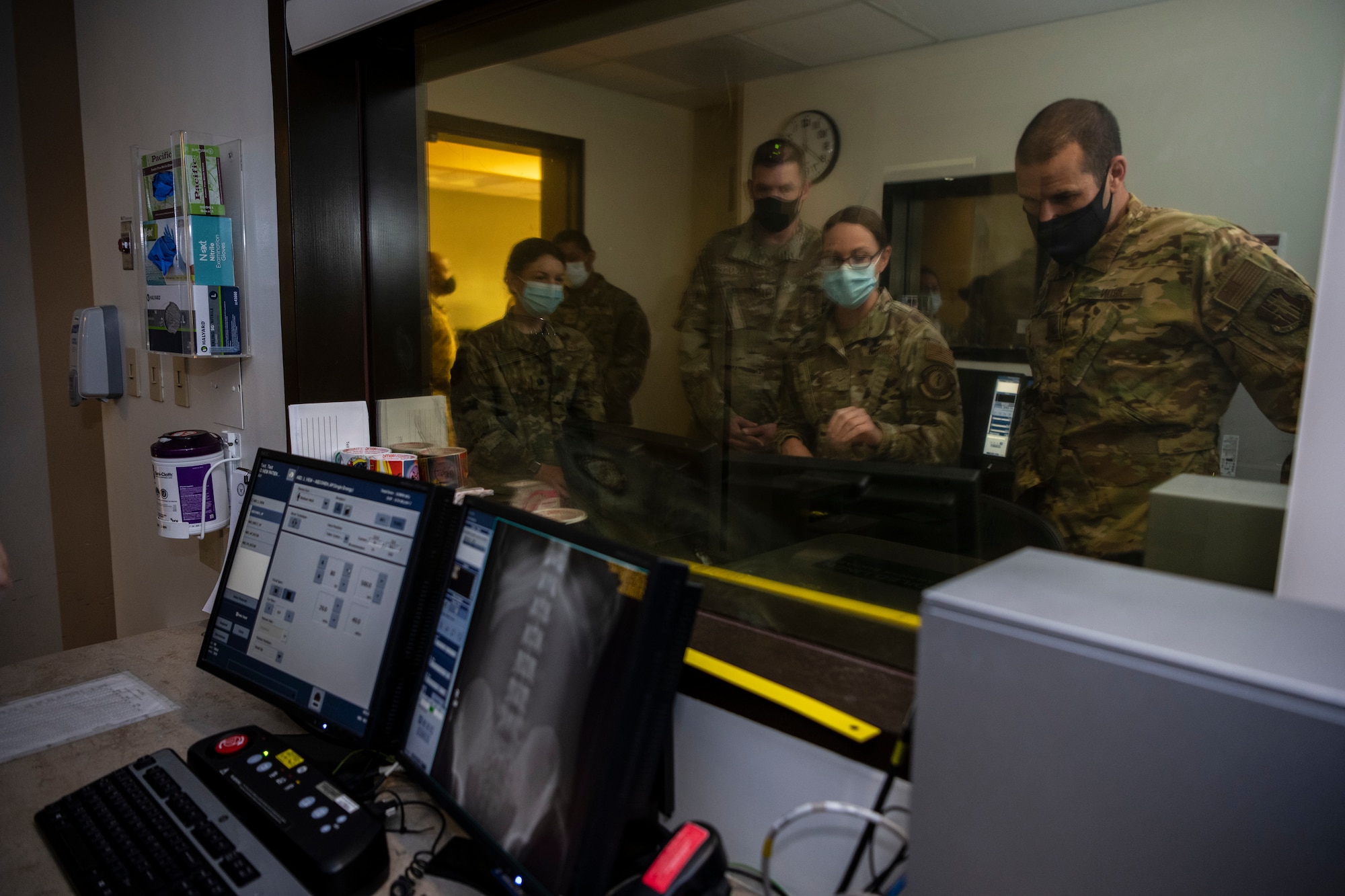 An Airman teaches much higher ranking Airmen how to x-ray a patient.