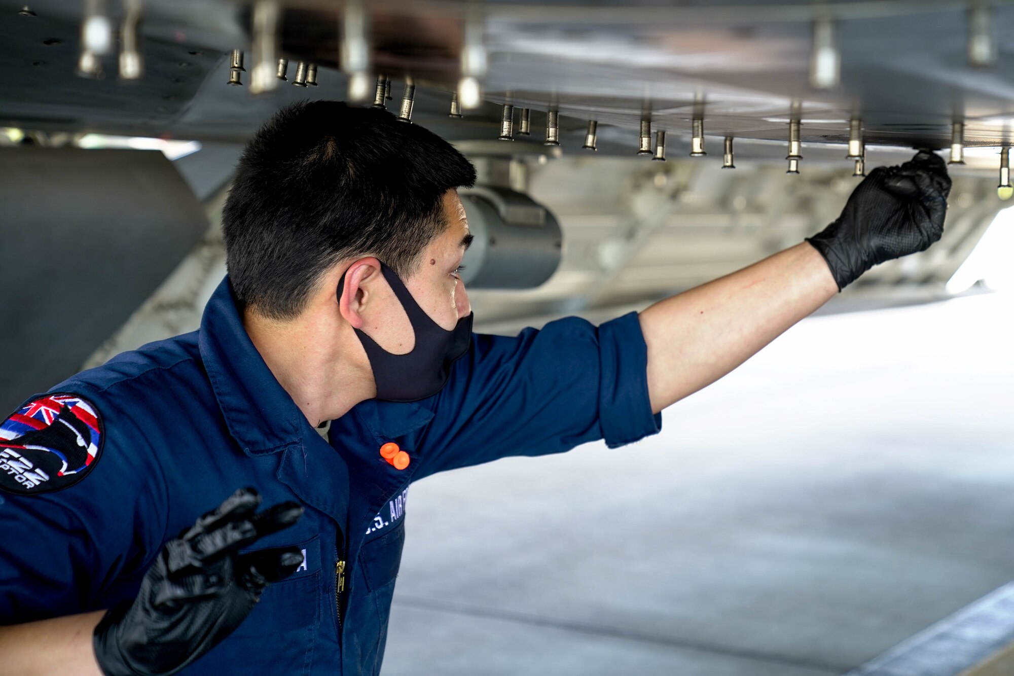 Senior Airman Cody Sonomura, 154th Aircraft Maintenance Squadron crew chief, performs routine maintenance checks on an F-22 Raptor on the flightline at Joint Base Pearl Harbor-Hickam, Hawaii, March 17, 2021. The 15th AMXS and the 154th AMXS work together to support the F-22 Raptor mission by performing aircraft inspections, servicing, launch and recovery, and maintenance repair actions for all assigned aircraft. (U.S. Air Force photo by Airman 1st Class Makensie Cooper)