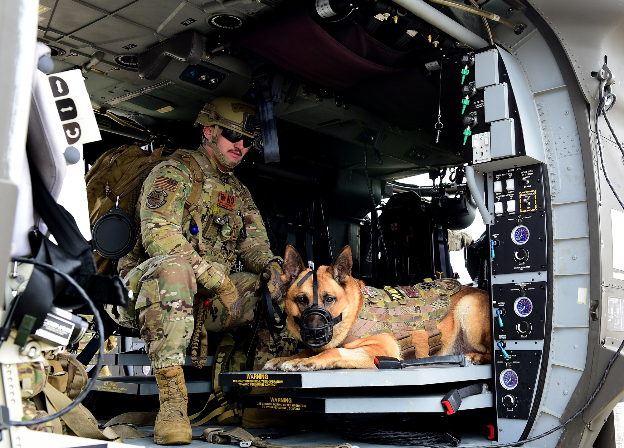 Senior Airman Austin West, 8th Security Forces Squadron military working dog handler, and MWD Bonus, sit inside a U.S. Army HH-60M Black Hawk helicopter for familiarization training during a joint medevac training event at Kunsan Air Base, Republic of Korea, April 13, 2021. The handlers gradually exposed the MWDs to the helicopters to familiarize them with the noises and vibrations to reduce their anxiety while flying. (U.S. Air Force photo by Senior Airman Suzie Plotnikov)