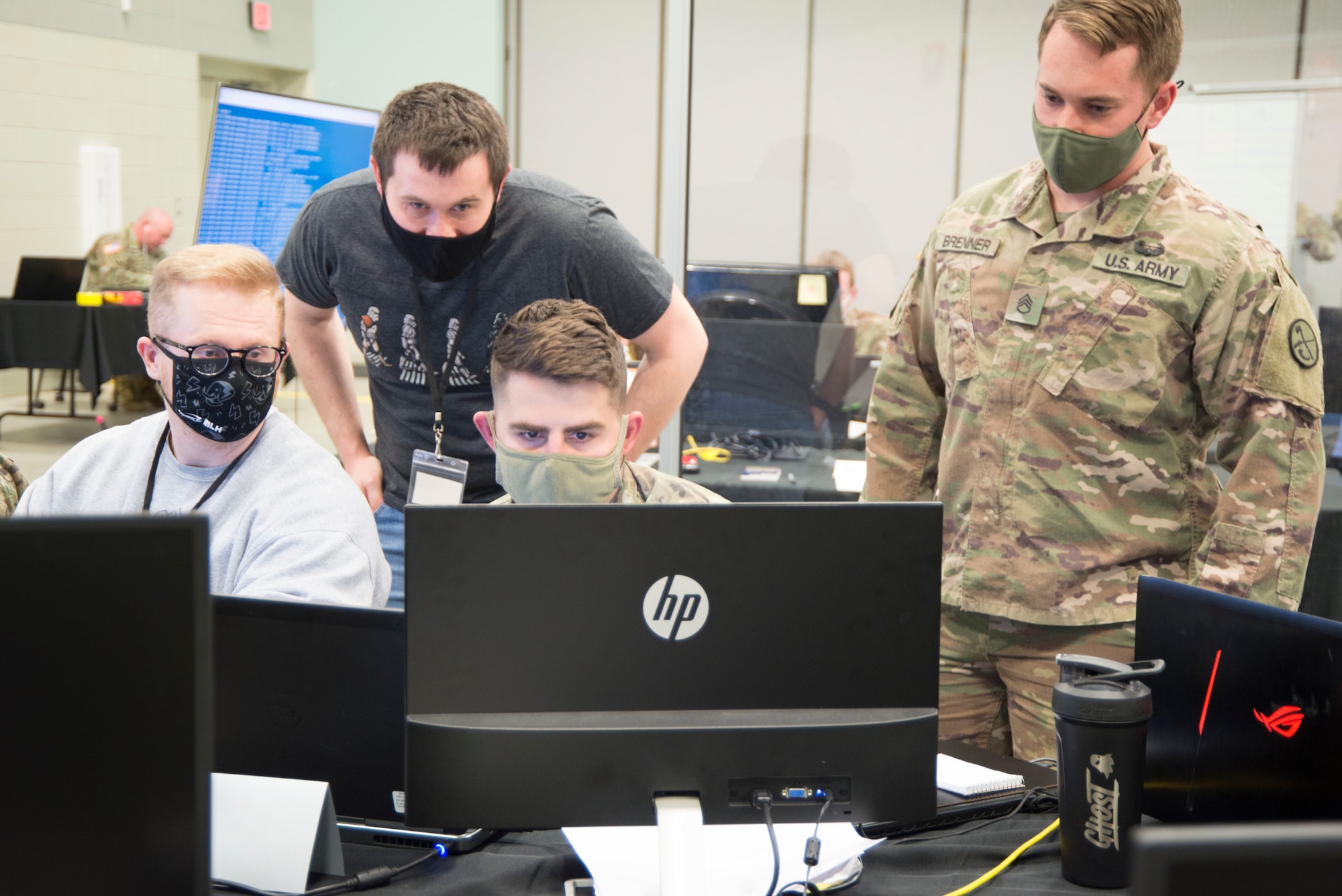 U.S. Army Staff Sgt. Paul Coffy, center, seated, views a virtual exercise environment as two West Virginia University students and U.S. Army Staff Sgt. Adam Brenner, right, observe at the Morgantown National Guard Readiness Center. The international Locked Shields 2021 cyber defense exercise was held the week of April 12, 2021.