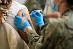 A Hospital Corpsman vaccinates a community member at the Tulsa Community Vaccination Center.