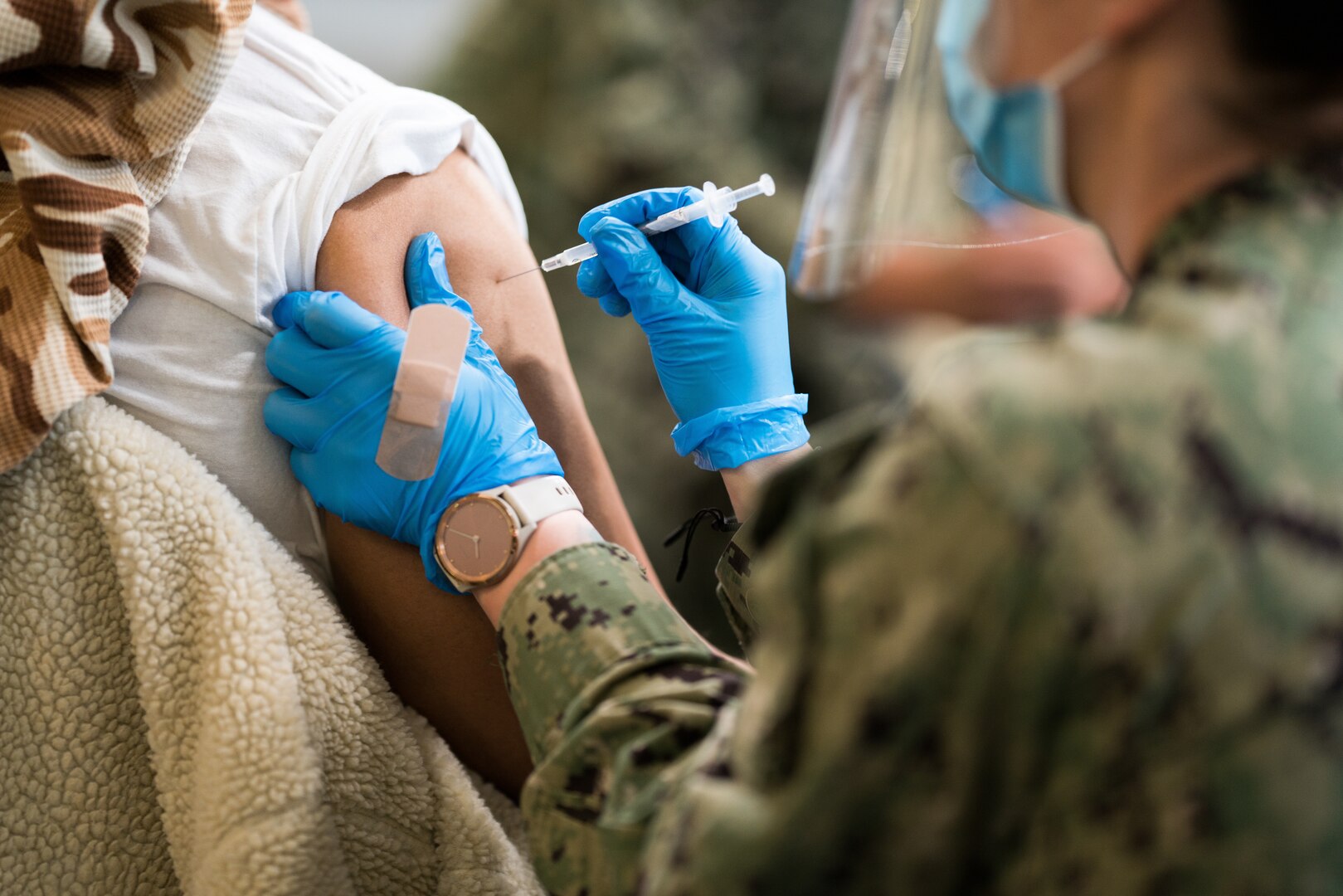 A Hospital Corpsman vaccinates a community member at the Tulsa Community Vaccination Center.