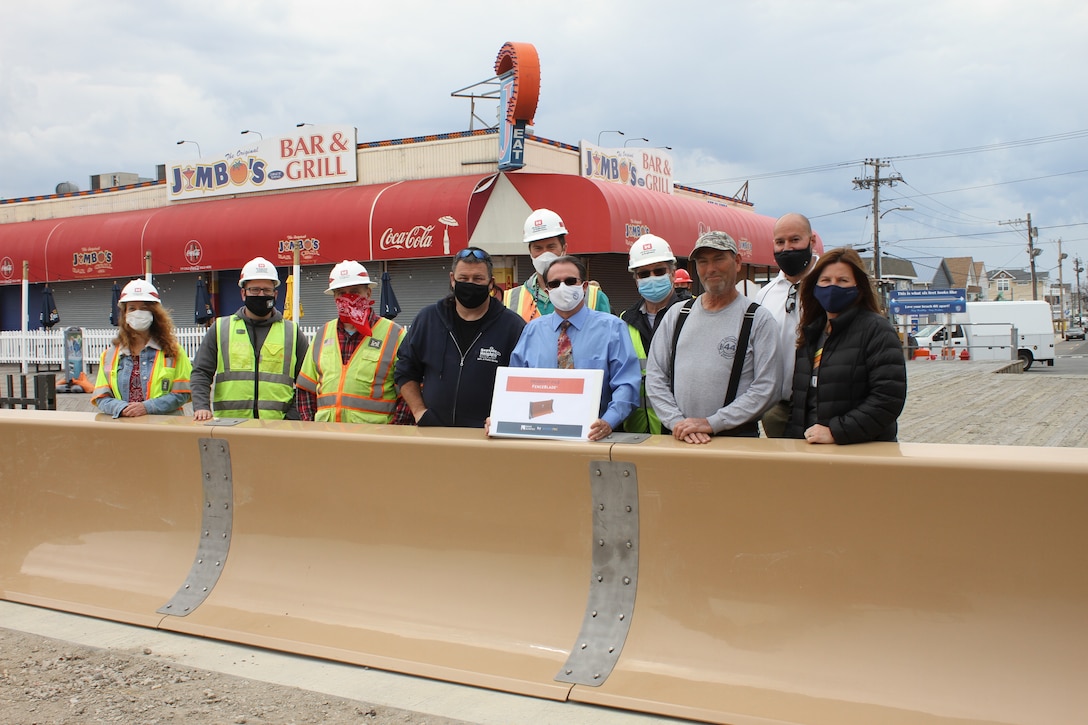 Team members pose in front of the removeable flood barrier in Seaside Heights, NJ