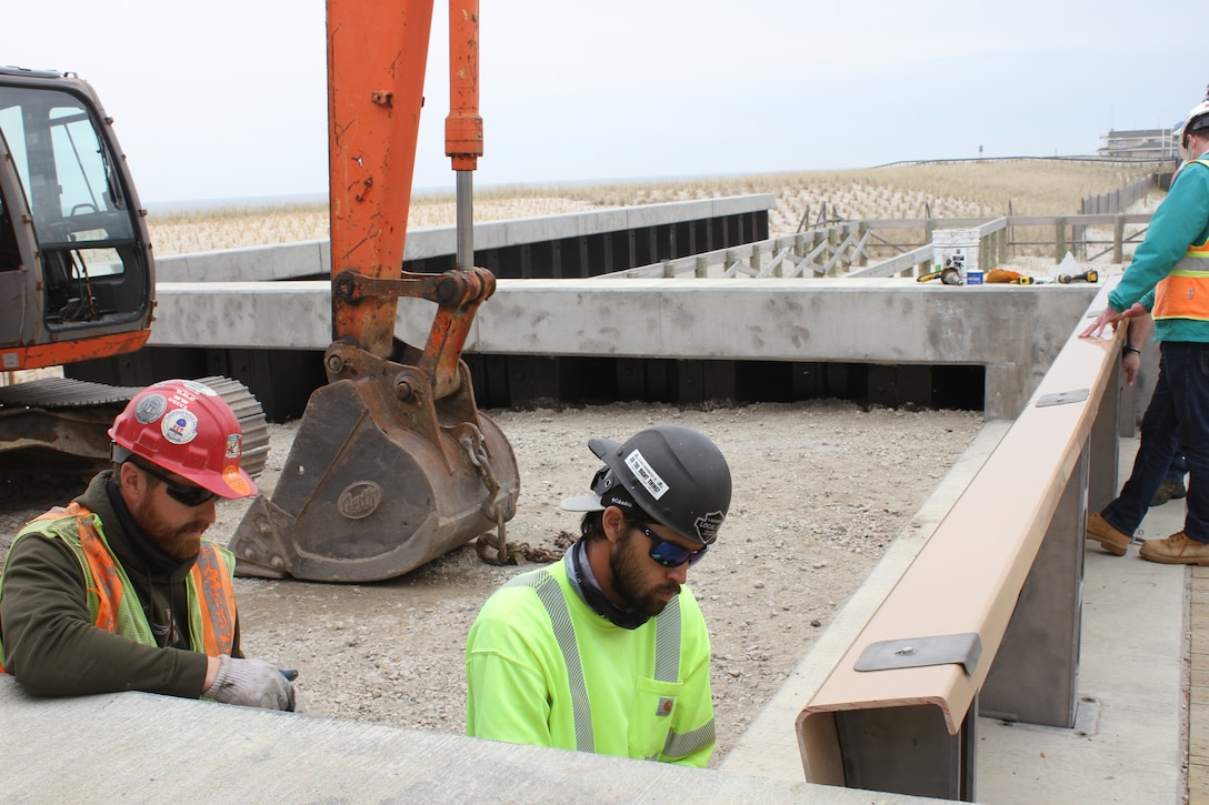 Contractors work to remove a flood barrier panel