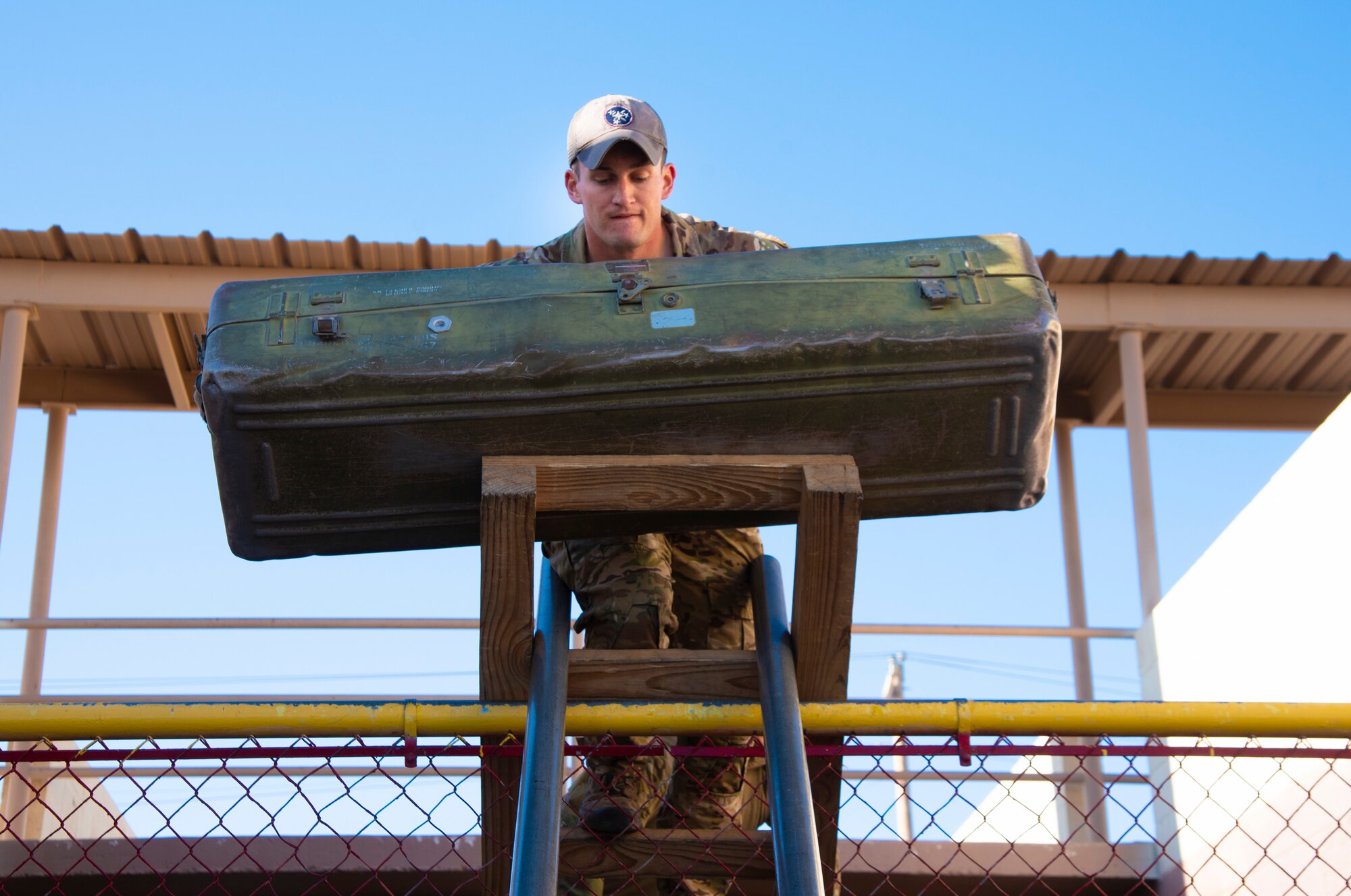 A U.S. Air Force Tactical Air Control Party specialist carries an equipment case over a fence during the 2021 Wraith Challenge, April 20, 2021, on Fort Bliss, Texas. Participants of the Wraith Challenge completed a leadership course where they solved problems like how to carry equipment and personnel over obstacles.  (U.S. Air Force photo by Airman 1st Class Jessica Sanchez)