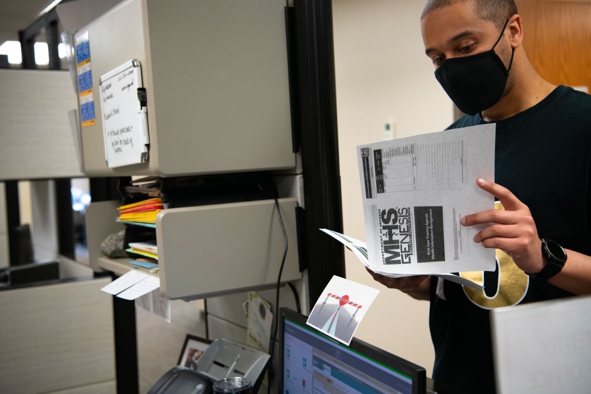Tech. Sgt. Sean Hollinger, a 28th Medical Group Tricare Operations Patient Administration flight chief, reviews an MHS Genesis instruction guide with his team at Ellsworth Air Force Base, S.D., April 24, 2021.