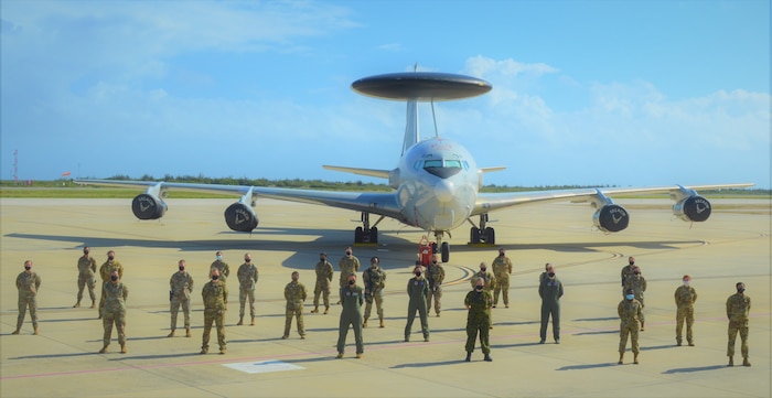 group photo of people in front of aircraft