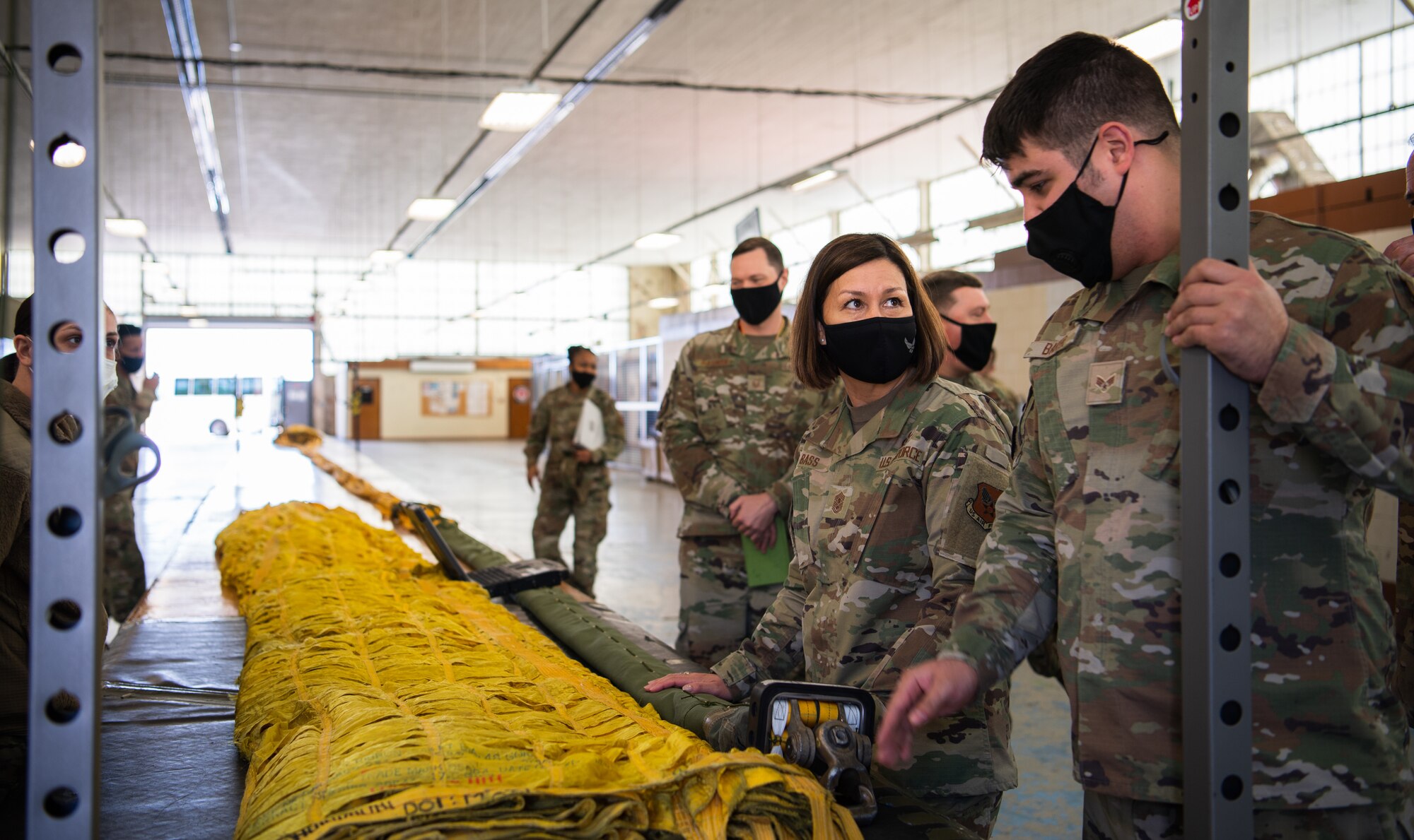 Chief Master Sgt. of the Air Force JoAnne S. Bass learns how to pack a B-52H Stratofortress parachute from Senior Airman Stuart Baker, 2nd Operations Support Squadron aircrew flight equipment journeyman, during her visit to Barksdale Air Force Base, Louisiana, April 22, 2021. Bass spent time with Airmen from across the installation, learning about their role in the mission of providing the nation with global strike capabilities. (U.S. Air Force photo by Airman 1st Class Jacob B. Wrightsman)
