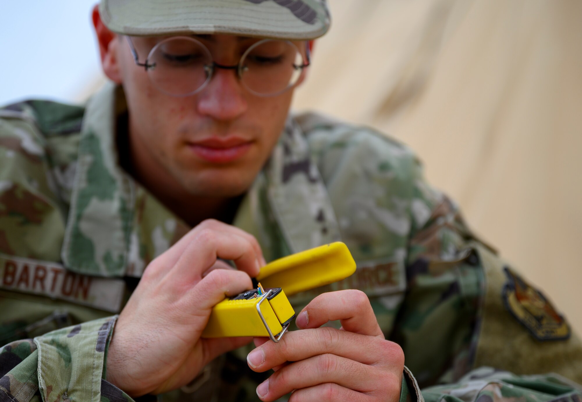 Airman 1st Class Quinn Barton, 378th Expeditionary Communications Squadron Cable and Antenna Maintenance technician, splices together wires during an update to the base Wi-Fi, Prince Sultan Air Base, Kingdom of Saudi Arabia, April 17, 2021. The communications team has been upgrading Wi-Fi connectivity at PSAB and increasing the number of access points. The Wi-Fi network serves to improve quality of life for deployed members and their ability to contact family and loved ones at home.. (U.S. Air Force Senior Airman Samuel Earick)