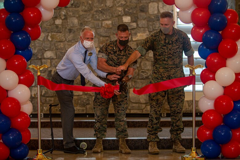 Steve Moran, the community services coordinator with Marine Corps Community Services (MCCS) Okinawa, U.S. Marine Corps Col. Matthew R. Nation, the commanding officer of Headquarters Battalion, 3rd Marine Division, and Brig. Gen. William J. Bowers, the commanding general of Marine Corps Installations Pacific, cut the ribbon to signify the grand opening of the MCCS Community Center on Camp McTureous, Okinawa, Japan, April 23, 2021. MCCS hosted the grand opening of the Camp McTureous Community Center which included a ribbon cutting ceremony to celebrate its addition to the installation. The center is available for Status of Forces Agreement members and their families to rent for a wide range of activities and events. (U.S. Marine Corps photo by Lance Cpl. Alex Fairchild)