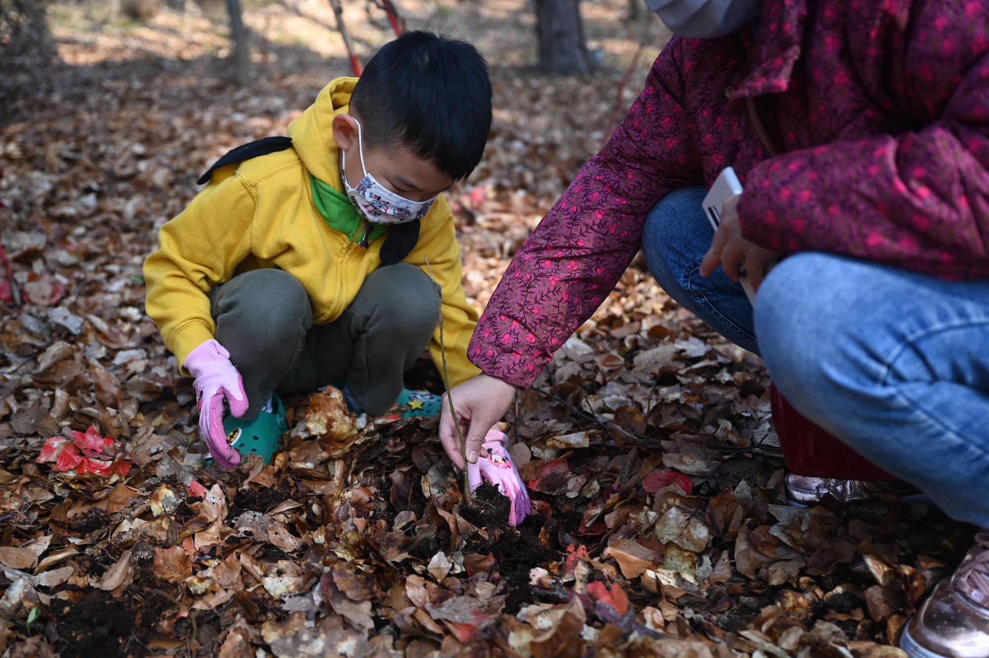 Bryce Ko (left) and Ujin Ko, U.S. Army spouse, plant an oak tree during Earth Day at Ramstein Air Base