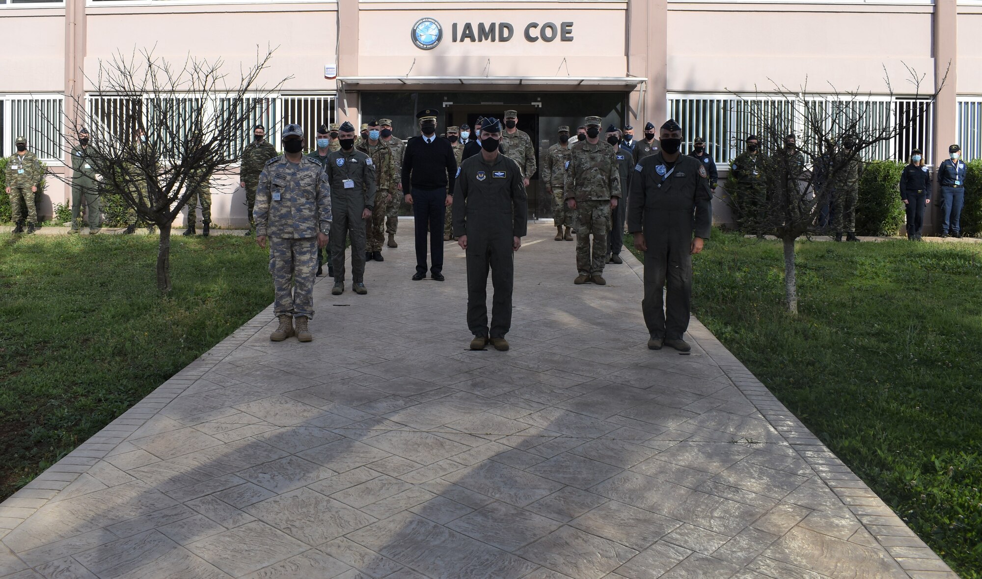 NATO military personnel pose in front of the Integrated Air and Missile Defense Center of Excellence before touring the facility in Chania, Crete, on April 21, 2020. The IAMD COE staff hosted participants of the two-day Command and Control Commanders Conference to visit their new facility.