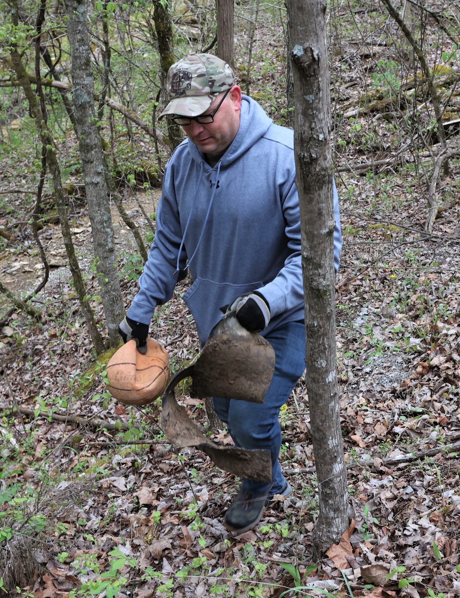 men and women gathering garbage and debris in the woods.