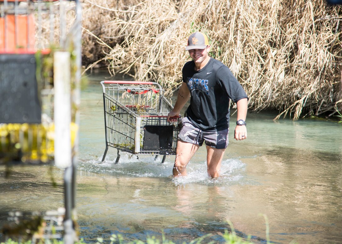 Second Lt. Rob Dau, 47th Student Squadron student pilot, pulls a shopping cart out of the San Felipe Creek during “STUS Serve Day”, on April 10, 2021, in Del Rio, Texas. STUS used this day to make improvements around the community and provide assistance wherever needed to showcase their admiration and commitment to the local community. (U.S. Air Force photo by Staff Sgt. Collette Brooks)