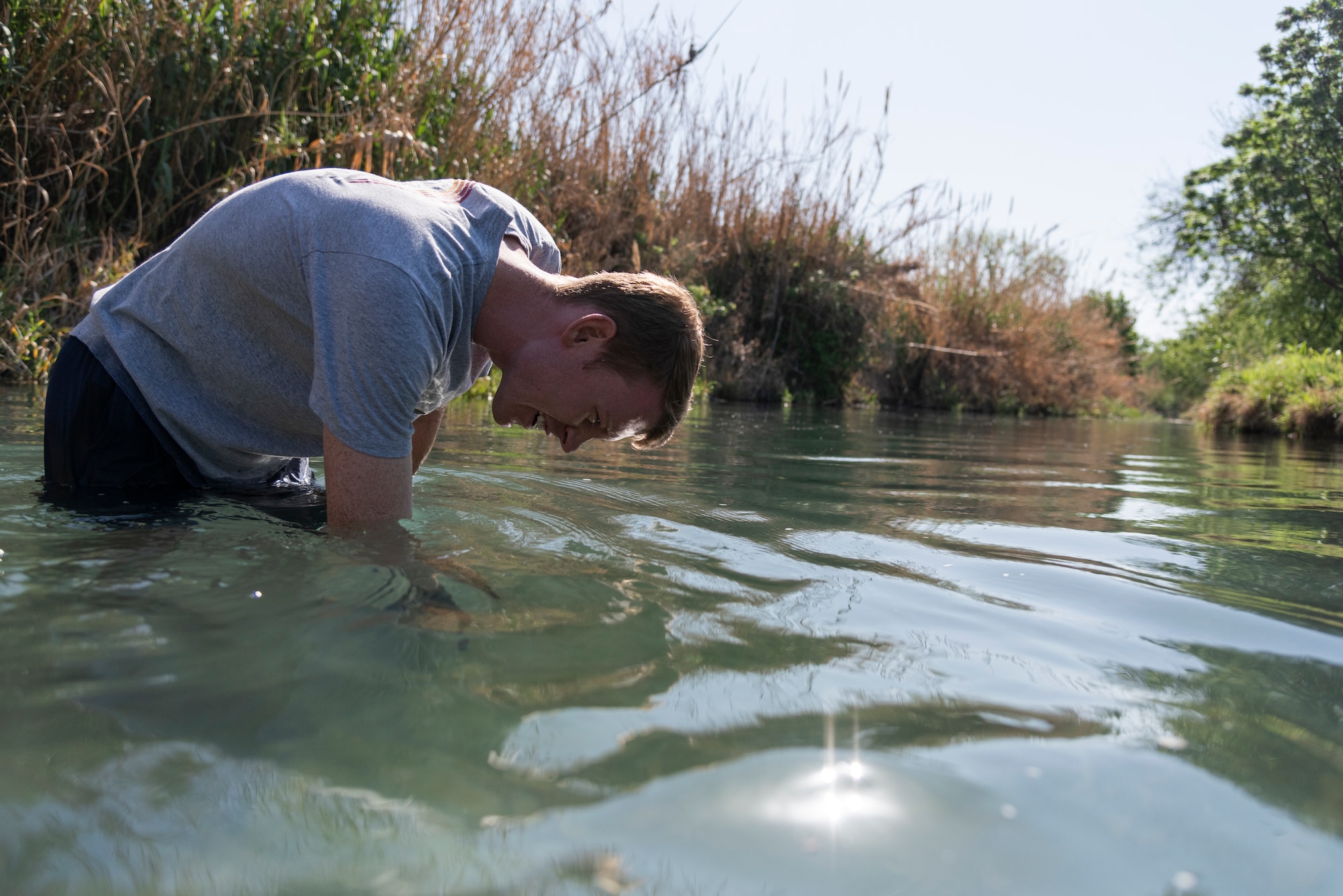 First Lt. Ryan Connors, 47th Student Squadron student pilot assigned to Laughlin Air Force Base, Texas, scans the scenic San Felipe Creek for debris to clear during STUS Serve Day on April 10, 2021, in Del Rio. More than 500 volunteers from base focused on revitalizing the San Felipe Amphitheater, Rubin Chavira Elementary School, Bobby Barrera Science, Technology, Engineering and Mathematics school, the Casa de la Cultura, Brown Plaza, AA Animal Rescue Coalition, a cemetery and numerous baseball and softball fields throughout town. (U.S. Air Force photo by Senior Airman Anne McCready)