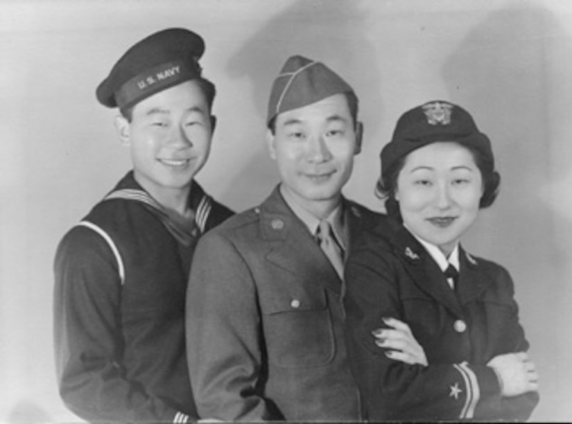 Two men and a woman in uniform pose for a photo.