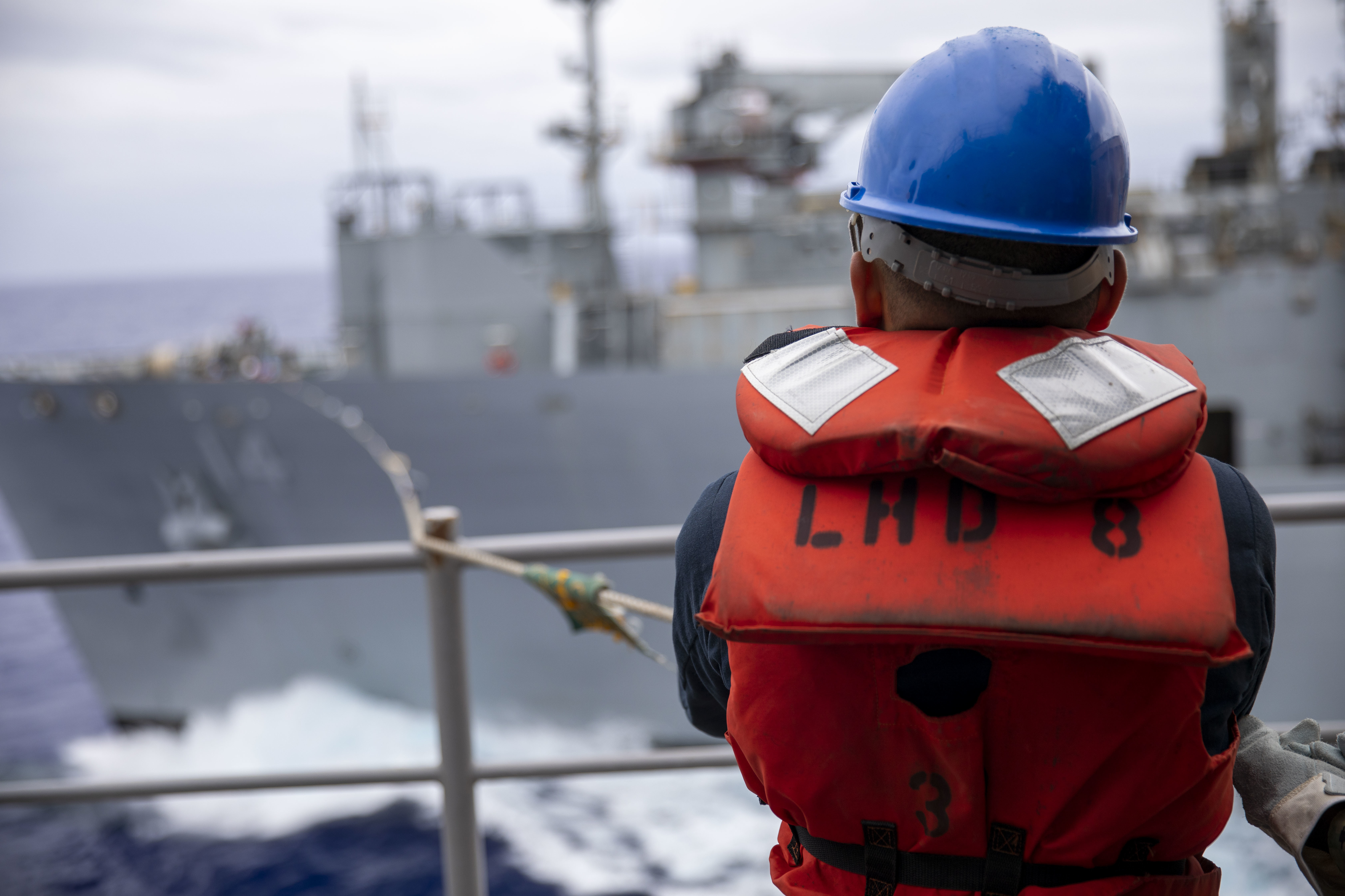 Seaman Reljan Laureta mans the phone-and-distance line aboard the amphibious assault ship USS Makin Island (LHD 8) during a replenishment-at-sea with the dry cargo and ammunition ship USNS Cesar Chavez (T-AKE 14).