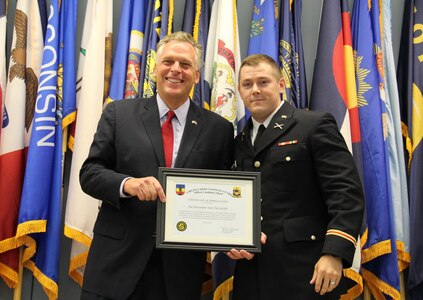 Second Lt. Daniel K. Frantzen presents Governor Terry McAuliffe with a certificate of appreciate for serving as the guest speaker for Officer Candidate School Class 56 July 26, 2014, at the 183rd Regiment, Regional Training Institute at Fort Pickett, Va.