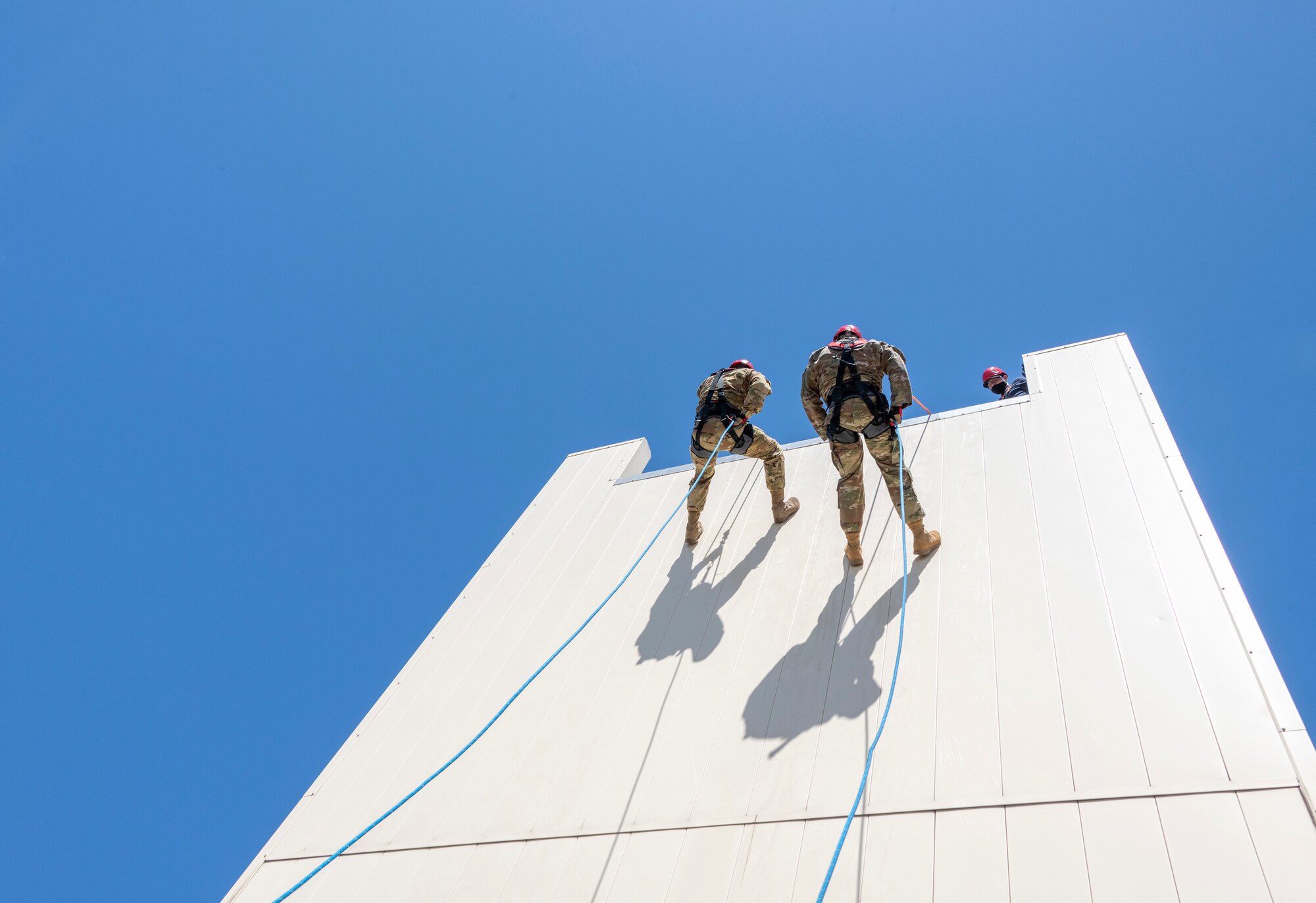 U.S. Air Force Staff. Sgt. Daniel Robinson, left, 60th Civil Engineer Squadron lead firefighter, and Major David Schoenhardt, 60th Civil Engineer Squadron Operations commander, rappel down a structure April 19, 2021, at the Travis Fire and Emergency Services training facility at Travis Air Force Base, California. The training demonstration provided senior leadership with a clear picture of the technical rescue capabilities for multi-story building and confined space rescues conducted by Travis AFB emergency response personnel. (U.S. Air Force photo by Heide Couch)