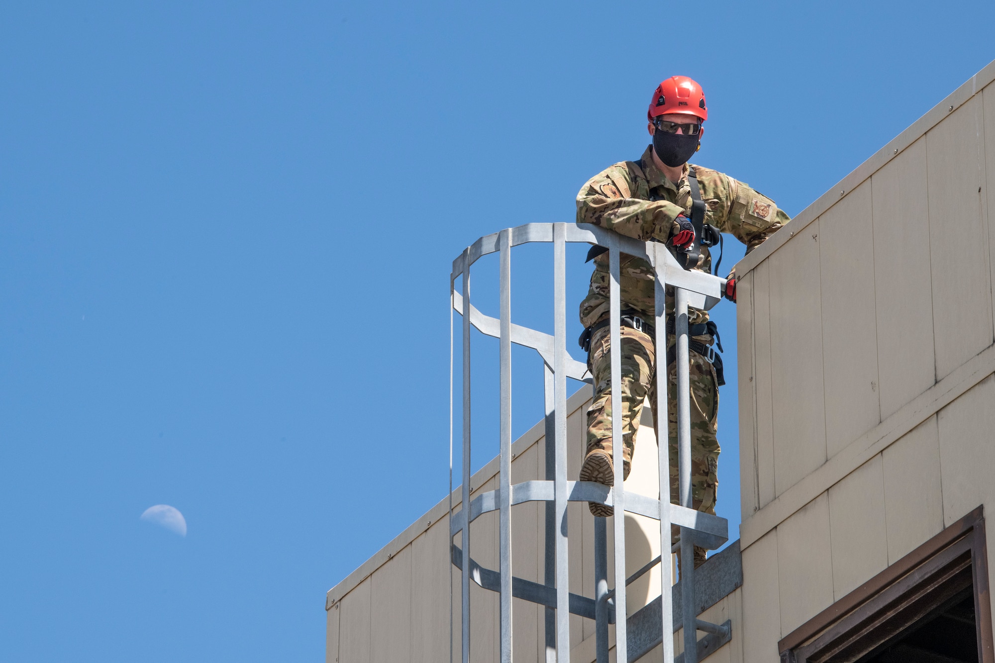 U.S. Air Force Staff. Sgt. Daniel Robinson, 60th Civil Engineer Squadron lead firefighter, climbs a ladder that leads to the roof of the structure used to train fire protection personnel April 19, 2021, at the Travis Fire and Emergency Services training facility at Travis Air Force Base, California. The training demonstration provided senior leadership with a clear picture of the technical rescue capabilities for multi-story building and confined space rescues conducted by Travis AFB emergency response personnel. (U.S. Air Force photo by Heide Couch)