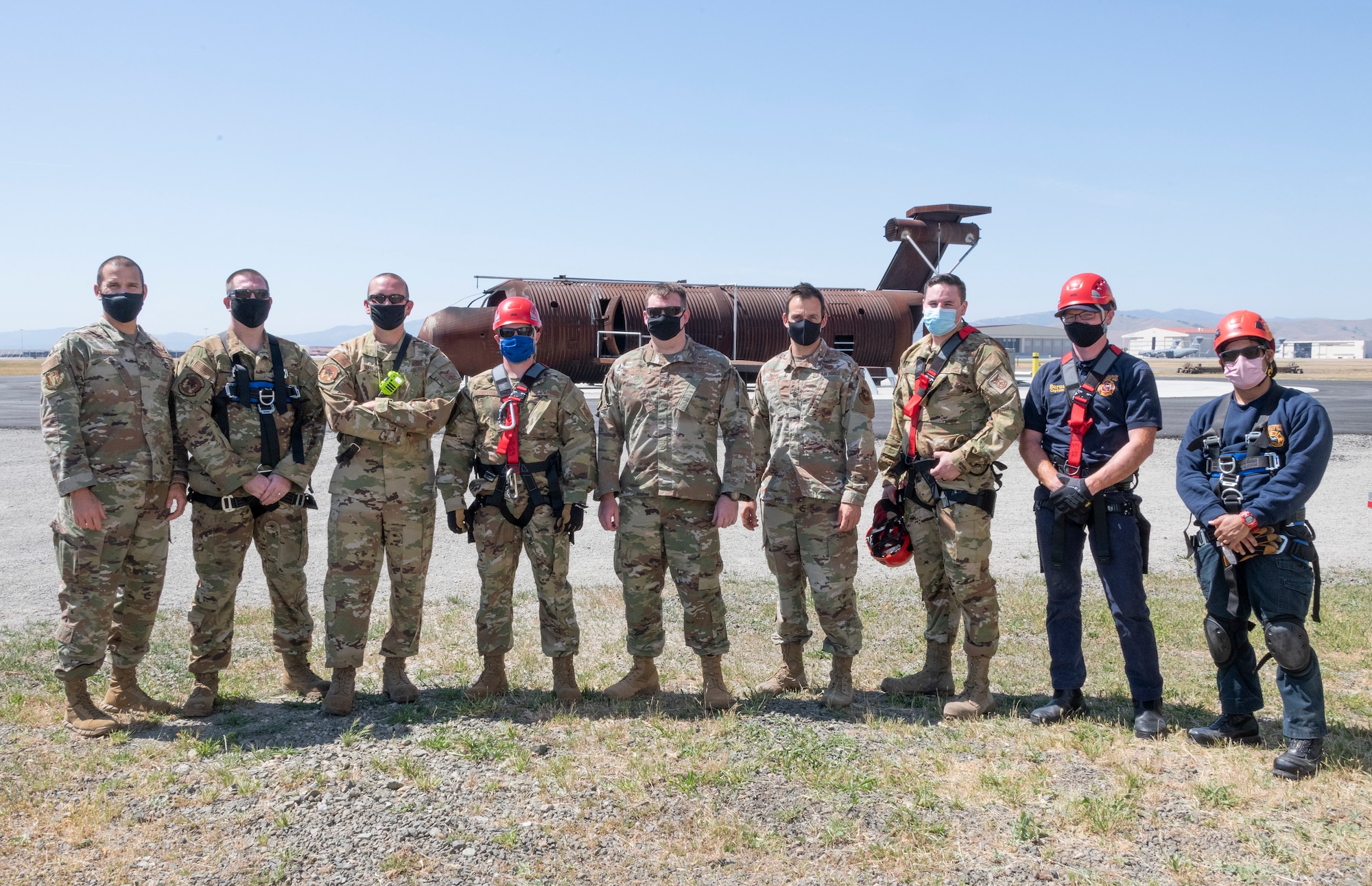 Senior leadership from Travis Air Force Base and members of the 60th Civil Engineer Squadron fire protection team stand in front of the aircraft structural fire simulator April 19, 2021, at the Travis Fire and Emergency Services training facility at Travis AFB, California. The fire protection team organized a demonstration that provided senior leadership with a clear picture of the technical rescue capabilities for multi-story building and confined space rescues conducted by Travis AFB emergency response personnel. (U.S. Air Force photo by Heide Couch)