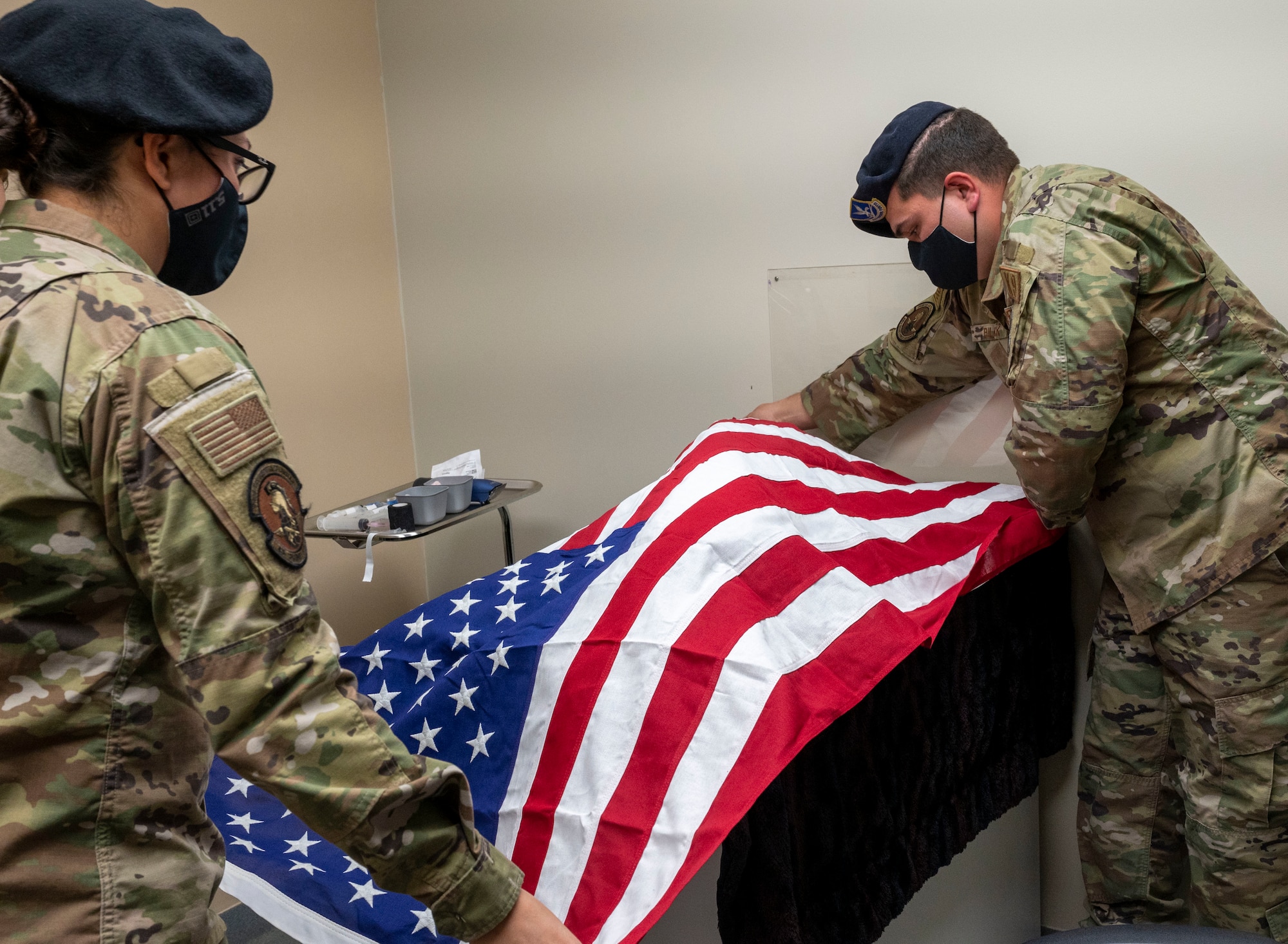 Staff Sgts. Theresa Braack and Dylan Bulick, both 436th Security Forces Squadron military working dog handlers, drape a flag over retired MWD Kali after she was humanely euthanized at the veterinary treatment facility on Dover Air Force Base, Delaware, April 22, 2021. Following seven years of service, Kali was euthanized after suffering from a tumor in her abdomen. (U.S. Air Force photo by Airman 1st Class Cydney Lee)