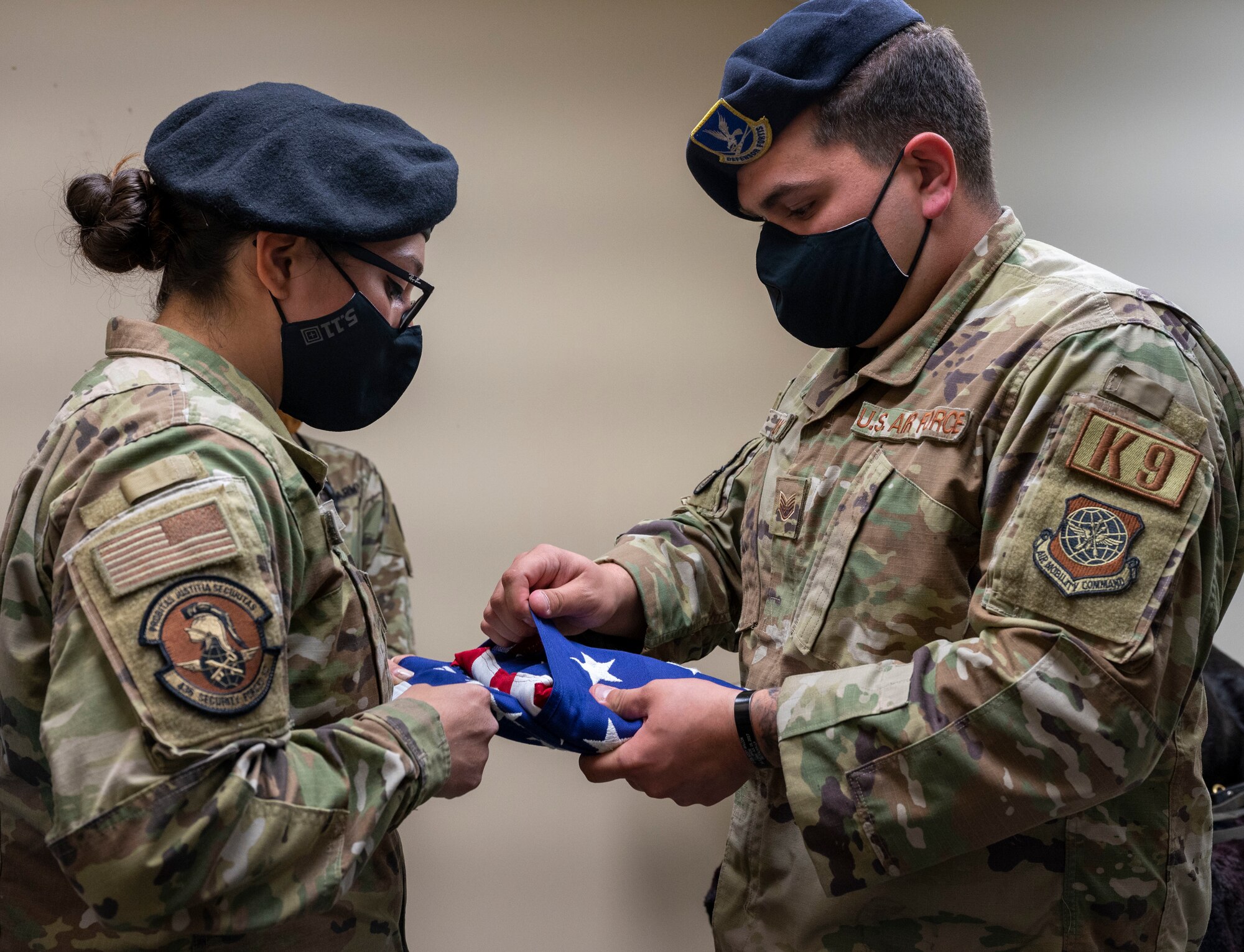 Staff Sgts. Theresa Braack and Dylan Bulick, both 436th Security Forces Squadron military working dog handlers, fold a flag for fallen retired MWD Kali at Dover Air Force Base, Delaware, April 22, 2021. Following seven years of service, Kali was humanely euthanized after suffering from a tumor in her abdomen. (U.S. Air Force photo by Airman 1st Class Cydney Lee)