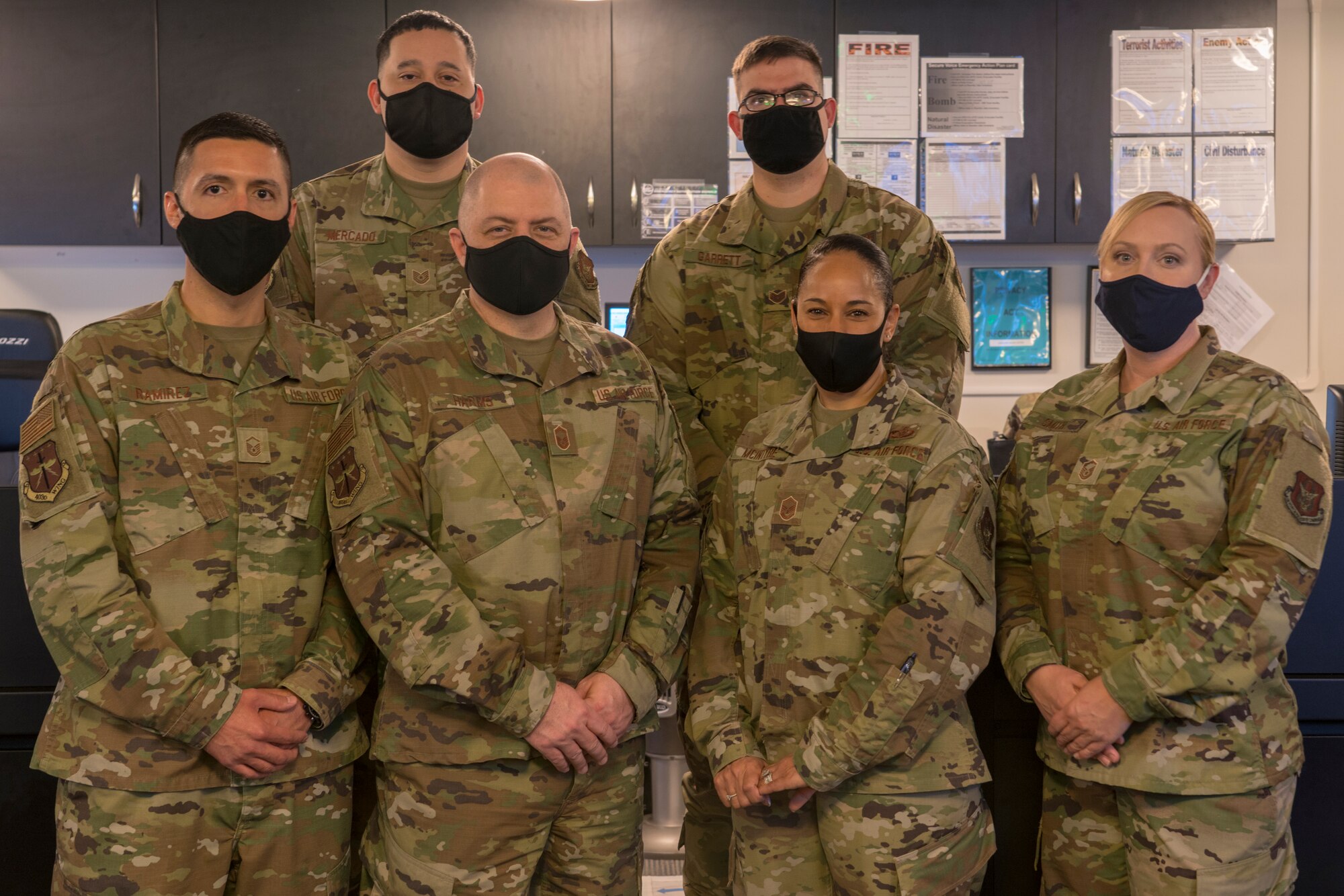 The 403rd Wing Command Post team: (back left to right) Tech. Sgt. Marvin Mercado, Staff Sgt. William Garrett, (front left to right) Master Sgt. Carlos Ramirez, Senior Master Sgt. Brian Harms, Master Sgt. Desirae McIntyre, and Master Sgt. Shawna Smith, pose for a photo at Keesler Air Force Base, Miss., April 11, 2021. The command post manages and performs a multitude of command and control operations that depending on the call they receive, can vary from minor issues to major incidents. (U.S. Air Force photo by 2nd Lt. Christopher Carranza)