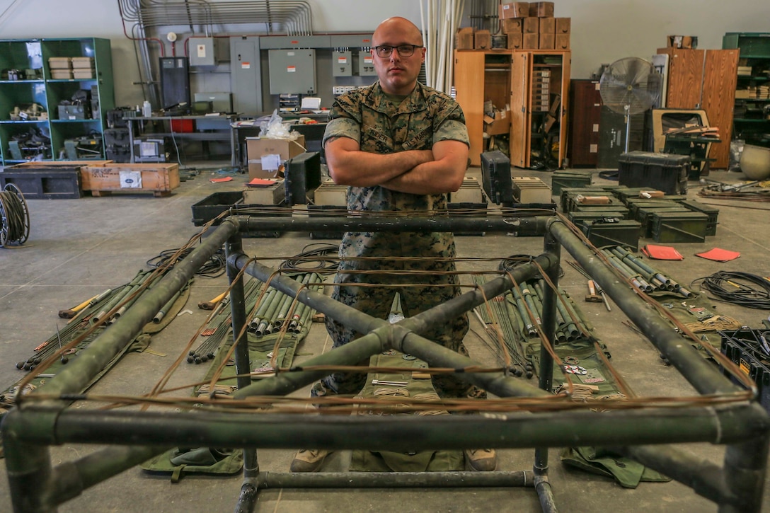 Cpl. Cameron Rider, a radio operator, shows off his award winning antenna design after winning the 1st MLG Innovation Award.