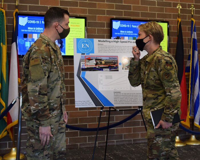 Capt. Aron Wing discusses his research on modeling high speed pin-on-disk experiment with Brig. Gen. Linell Letendre, dean of faculty, USAFA. Capt. Wing graduated from AFIT in 2021 with a master’s of science degree in applied mathematics.